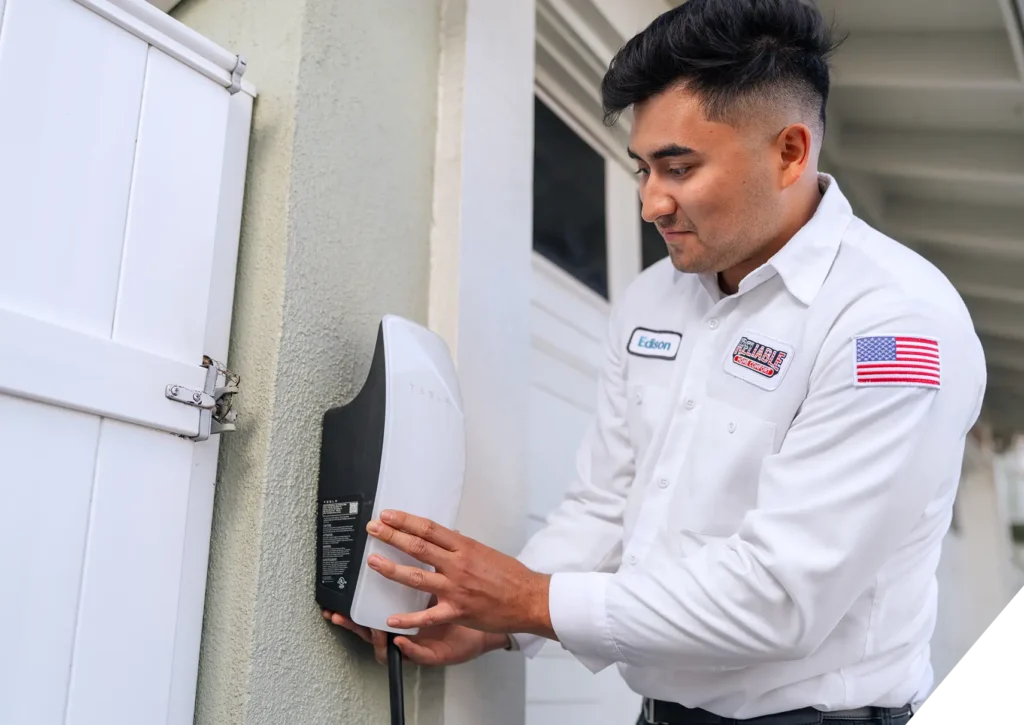 Reliable Home Comfort technician inspecting Tesla EV charger installation – electric vehicle charging station services in Los Angeles.