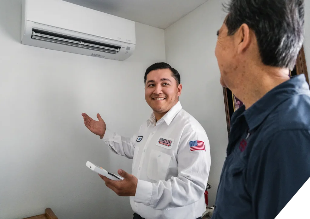 Reliable Home Comfort technician explaining wall-mounted ductless HVAC system to homeowner – Indoor Air Quality in Los Angeles.