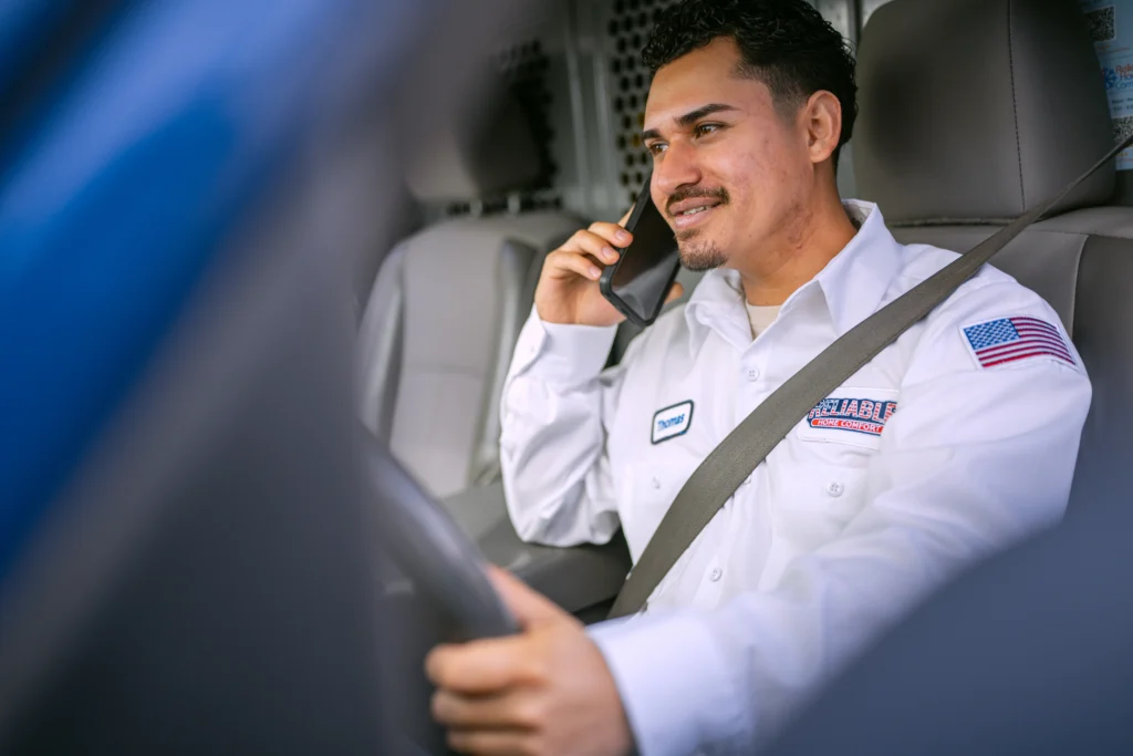 Reliable Home Comfort technician communicating with dispatch while en route to a service appointment in Norwalk, CA.